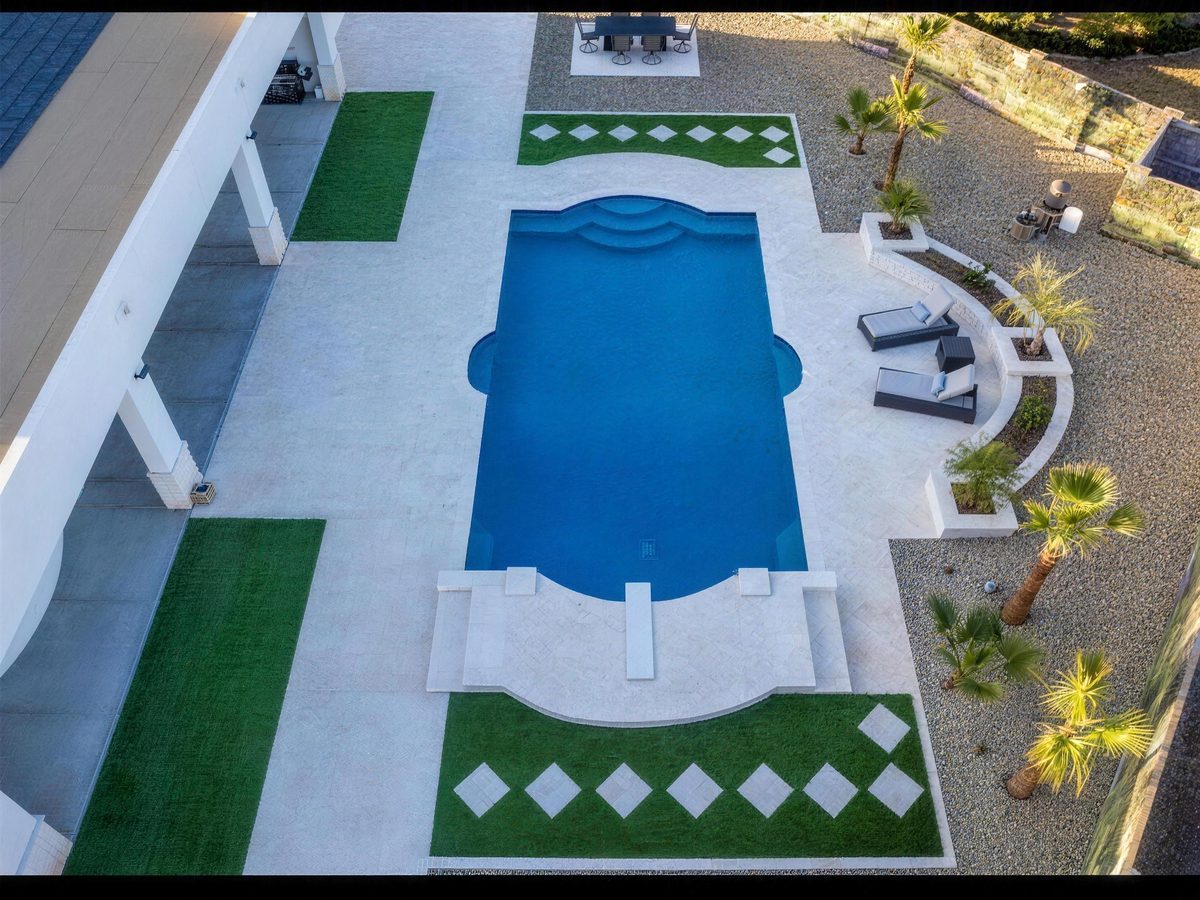 Top-down aerial of a rectangle pool with diamond paver inlays in turf