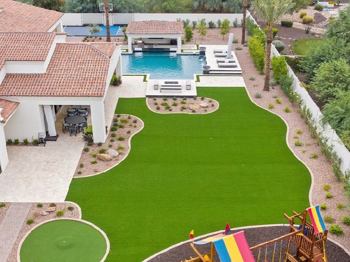 Family backyard with pool, casita, lawn, putting green and playset